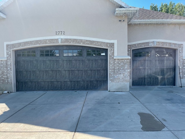 Two garage doors with a large window in front of a house, providing a functional and aesthetic addition to the property.