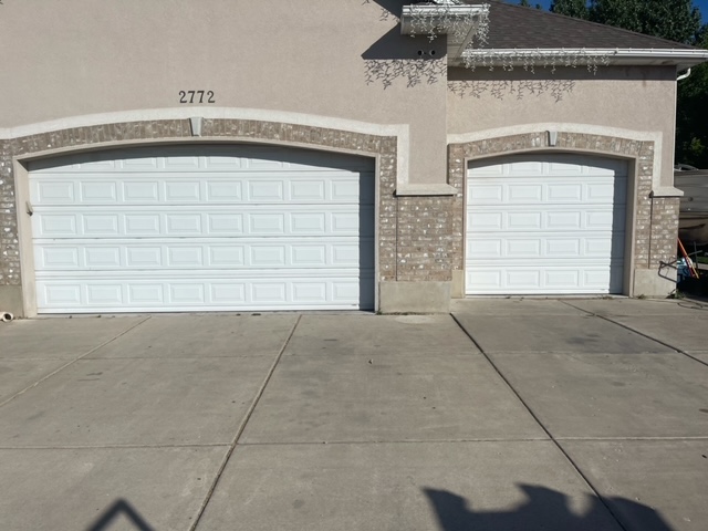 Dual white garage doors with brick arches