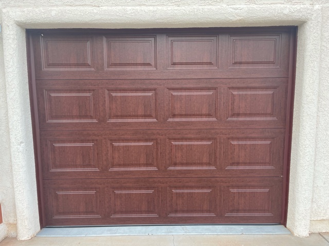 Stylish brown garage door featuring a crisp white trim, creating a classic and sophisticated look.