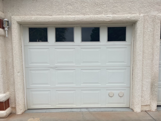 White garage door with side window, allowing natural light into the space.