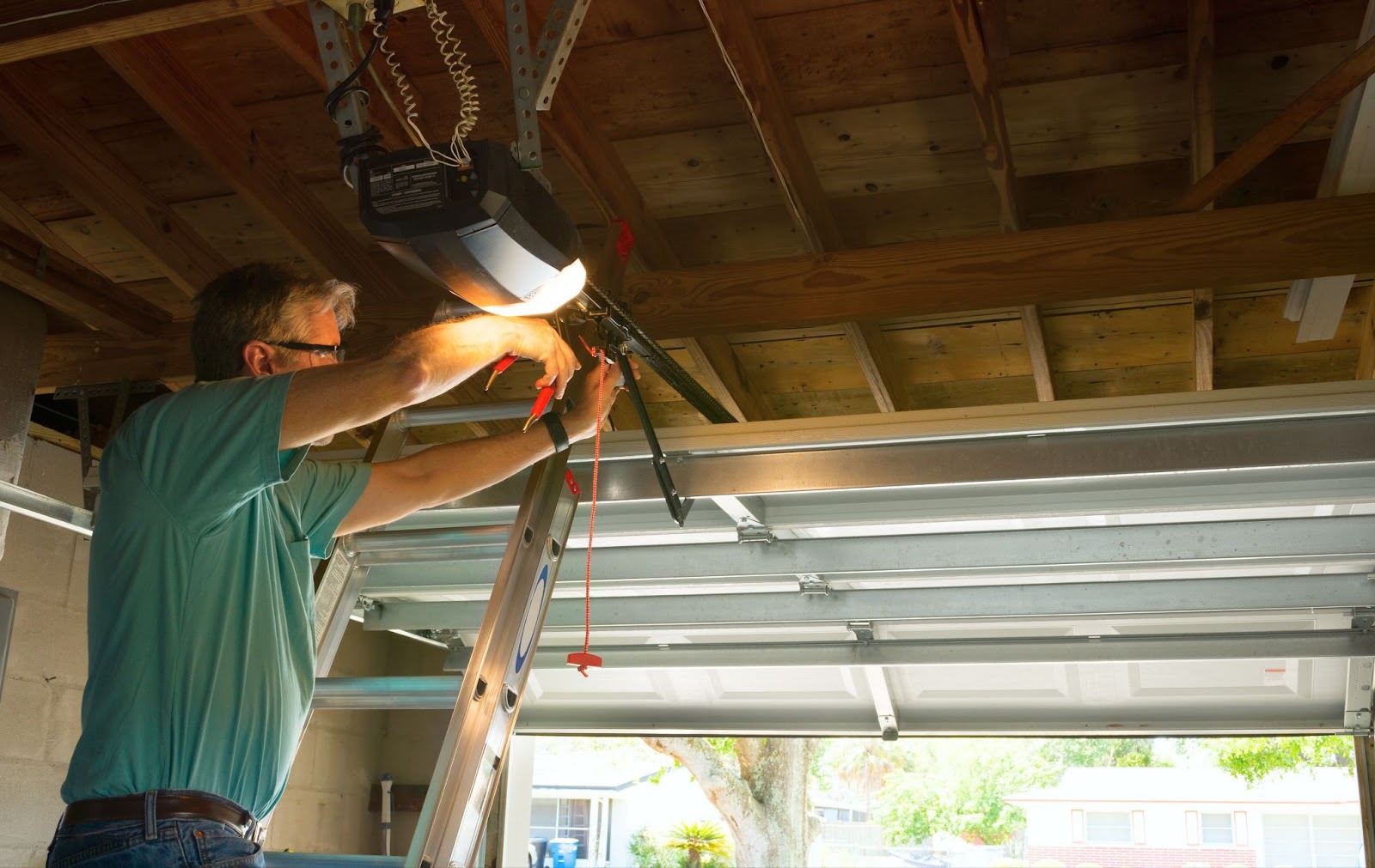 A man installing a garage door opener.