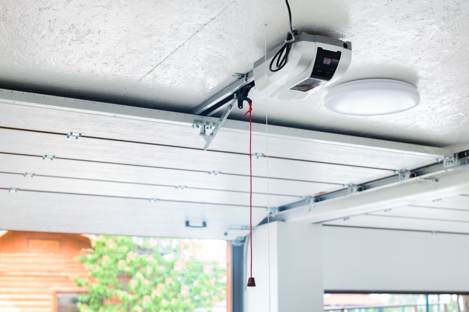 A modern garage door opener with remote control for new, insulated garage door.