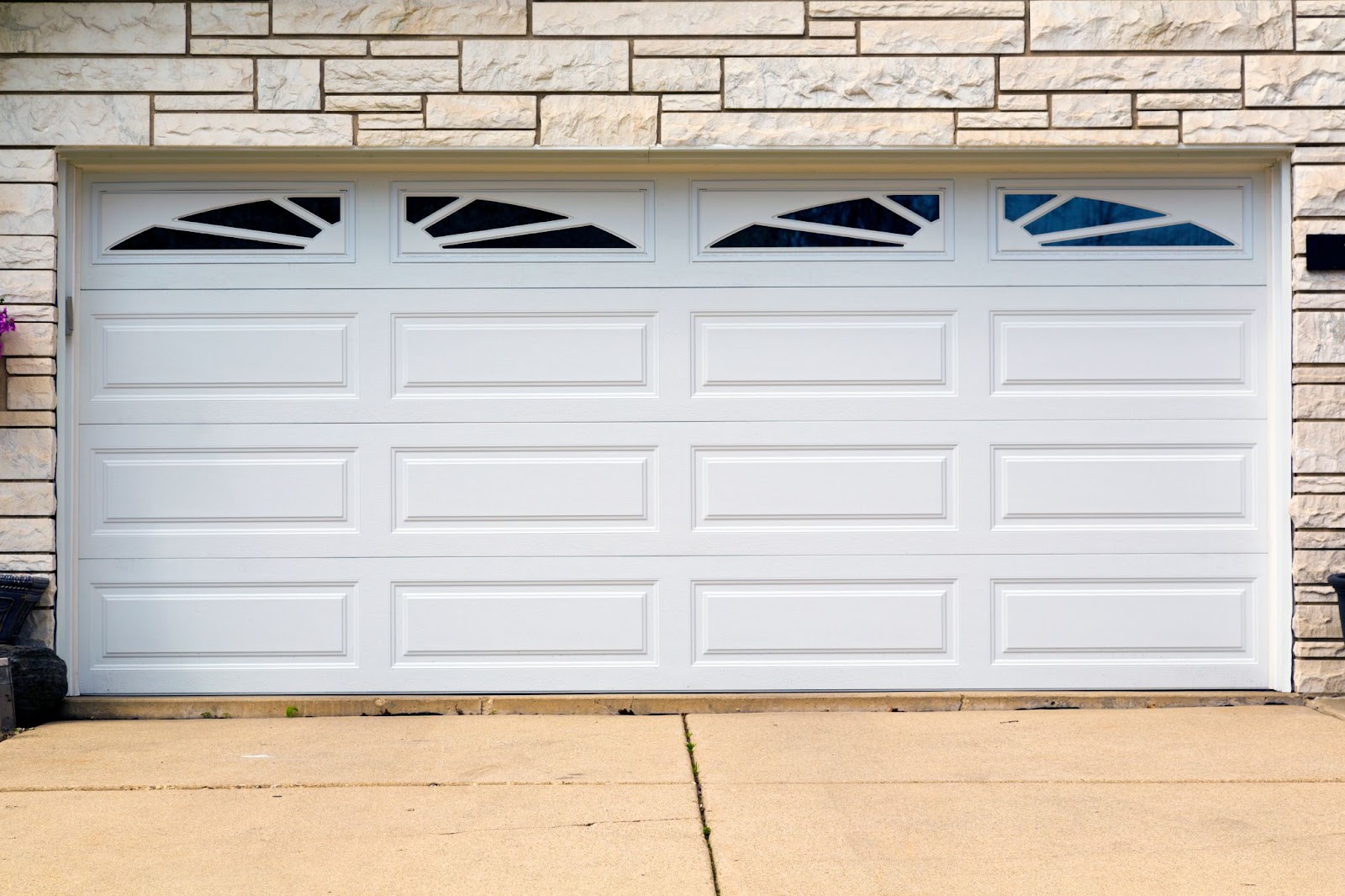 White insulated garage door with two windows, modern design.