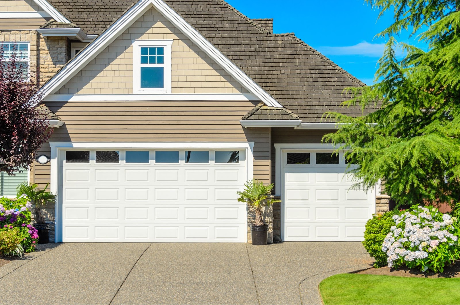 A large house featuring a well-maintained garage door and attractive landscaping, highlighting its professional appeal.