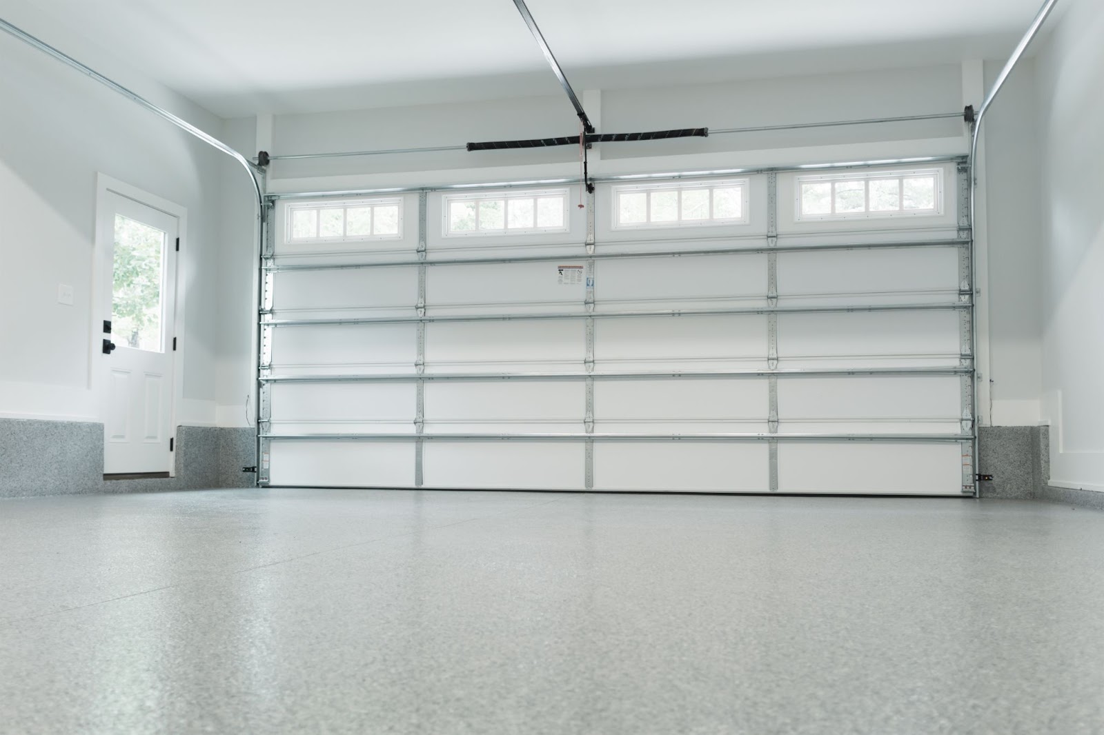 A white garage door with an opener, symbolizing professional garage door repair and solutions for common garage door issues.