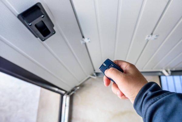 A person ready to open a garage door with a remote, emphasizing easy home entry