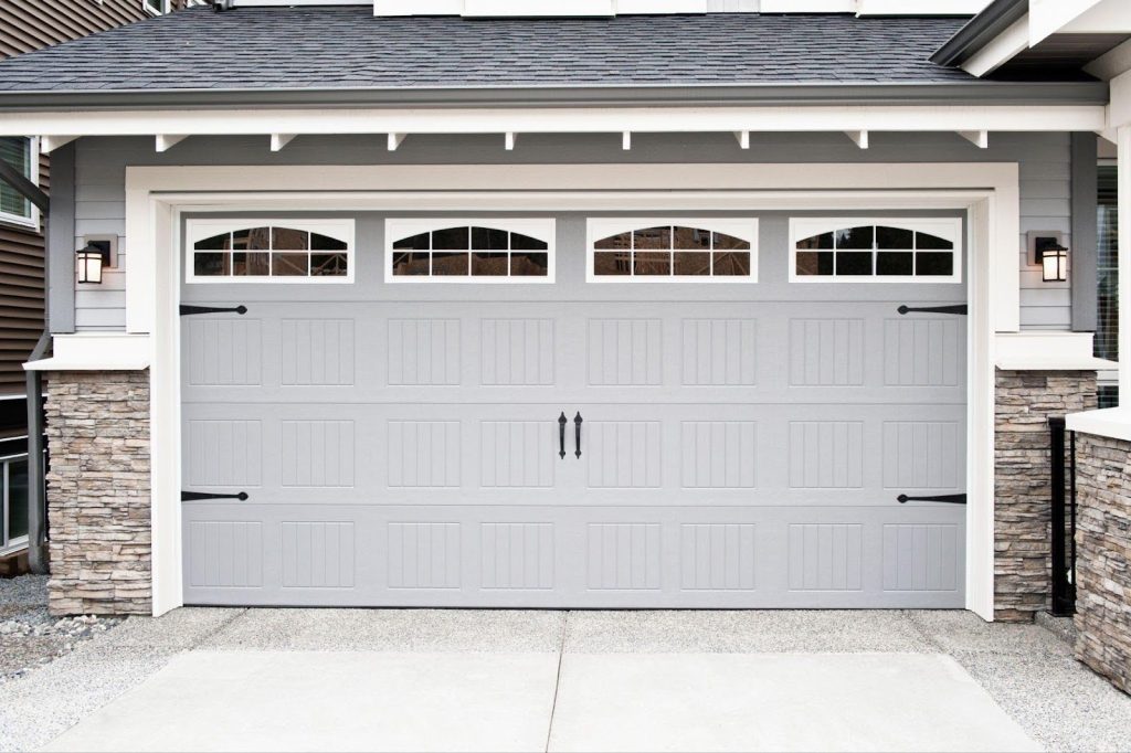 A gray garage door featuring windows, showcasing a modern and sleek design