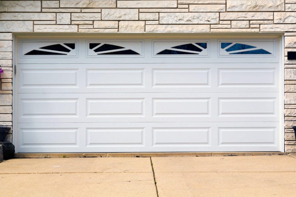 A white garage door adorned with two windows, enhancing the aesthetic appeal of the property