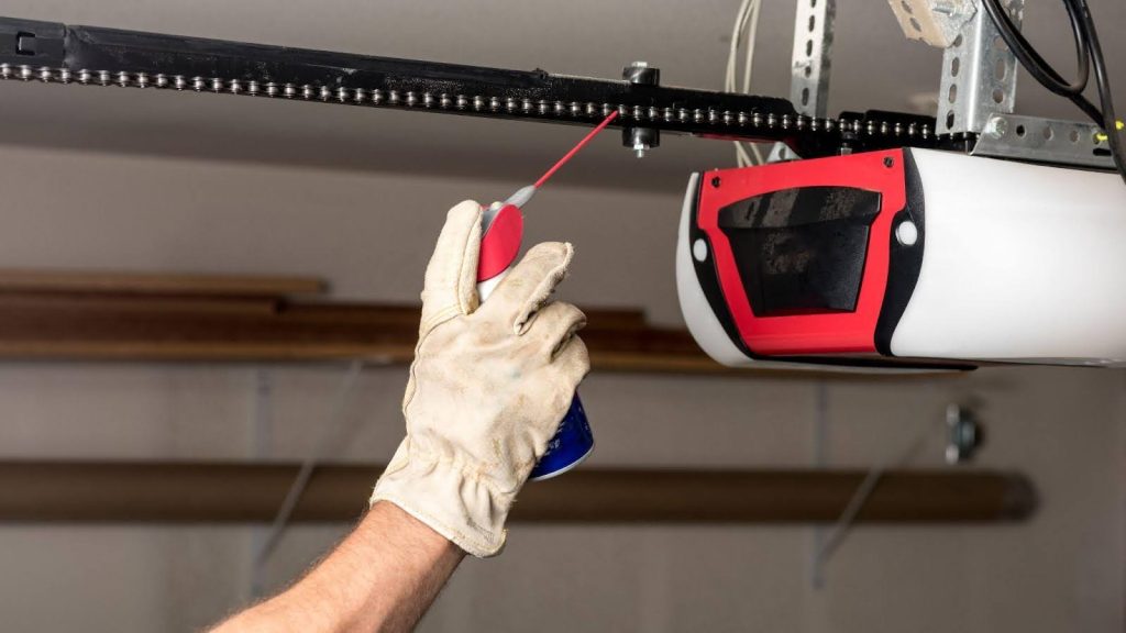 A technician repairing a garage door in Maryland, with tools for maintenance