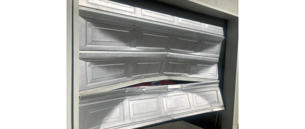 Damaged garage door panel and spring hardware in Bountiful, Utah