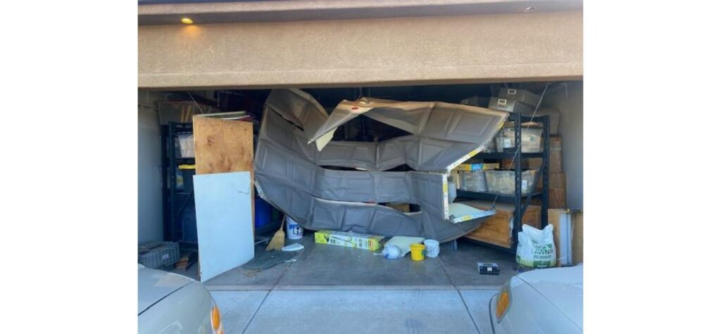 Severely damaged garage door requiring emergency repair in Clearfield, Utah